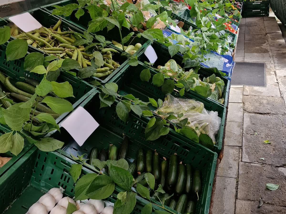 Kisten mit Bohnen, Gurken und Knoblauch vor dem Laden