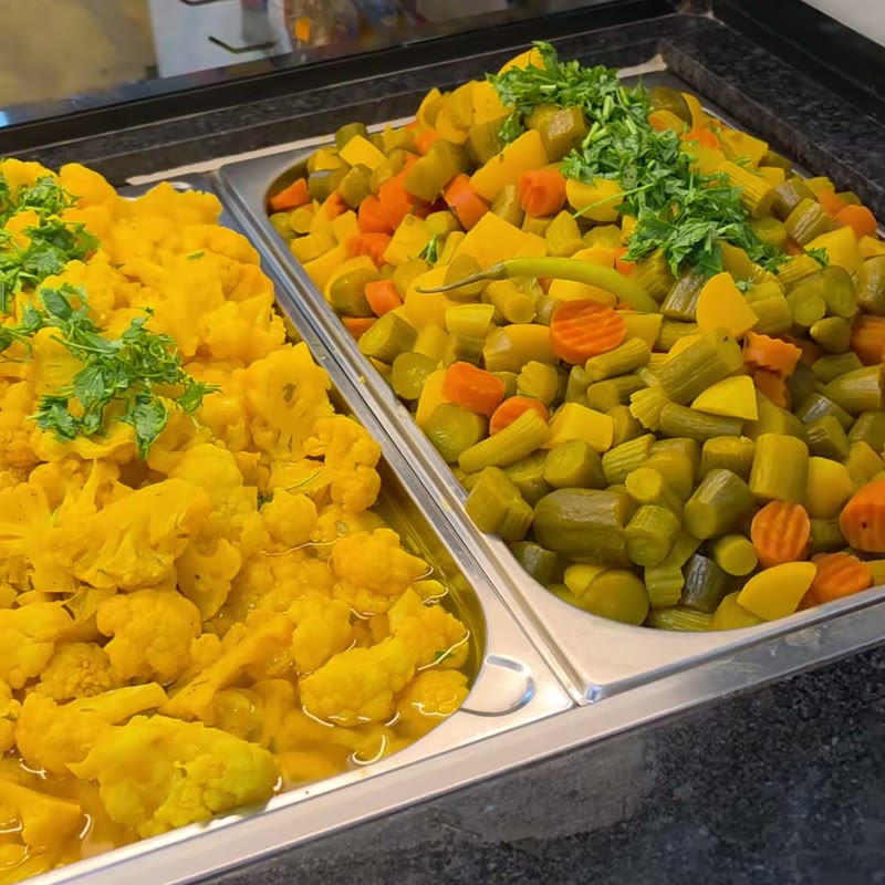 Gelb eingelegter Blumenkohl und gemischtes Torshi mit Gurke, Karotte und Peperoni in der Theke