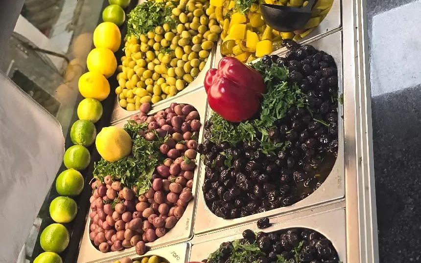 Oliven, eingelegtes Gemüse, rote Paprika und Zitronen in der Theke